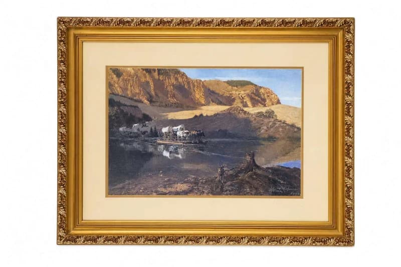 Ornate gilt-framed western landscape painting with canyon and wagon scene